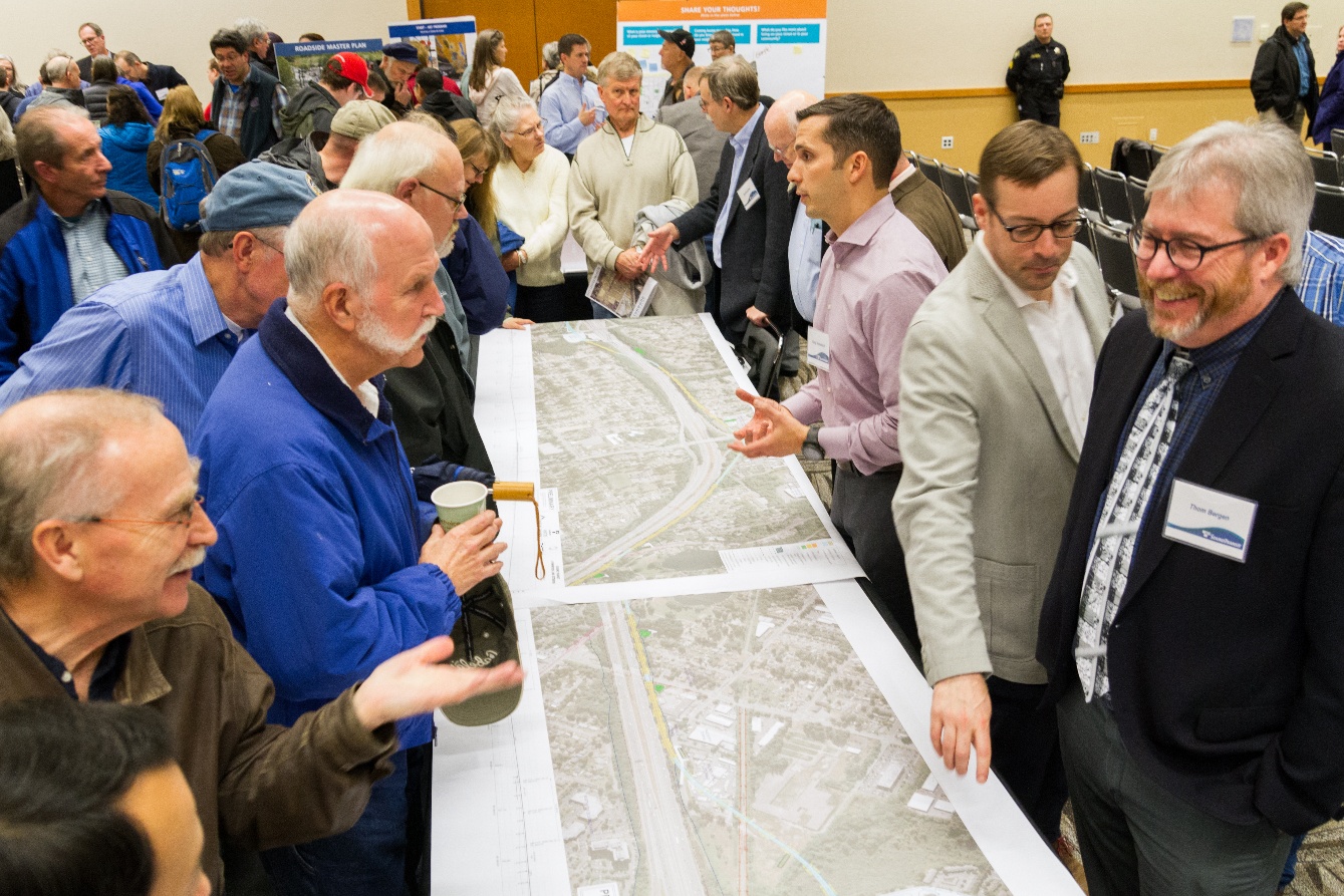 Community members and Sound Transit staff reviewing project maps at an in-person drop-in session